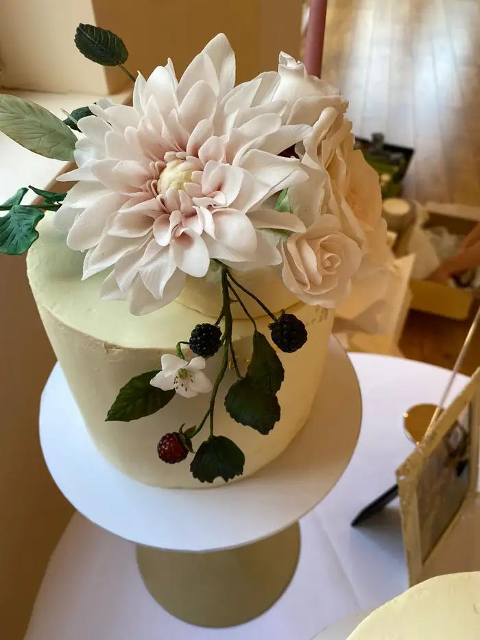 White celebration cake with sugar dahlia and roses